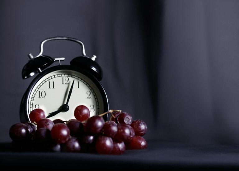 clock next to healthy food representing intermittent fasting schedule