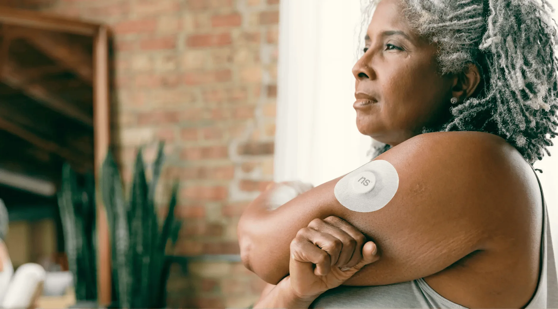 Person checking continuous glucose monitor CGM sensor on arm for prediabetes tracking