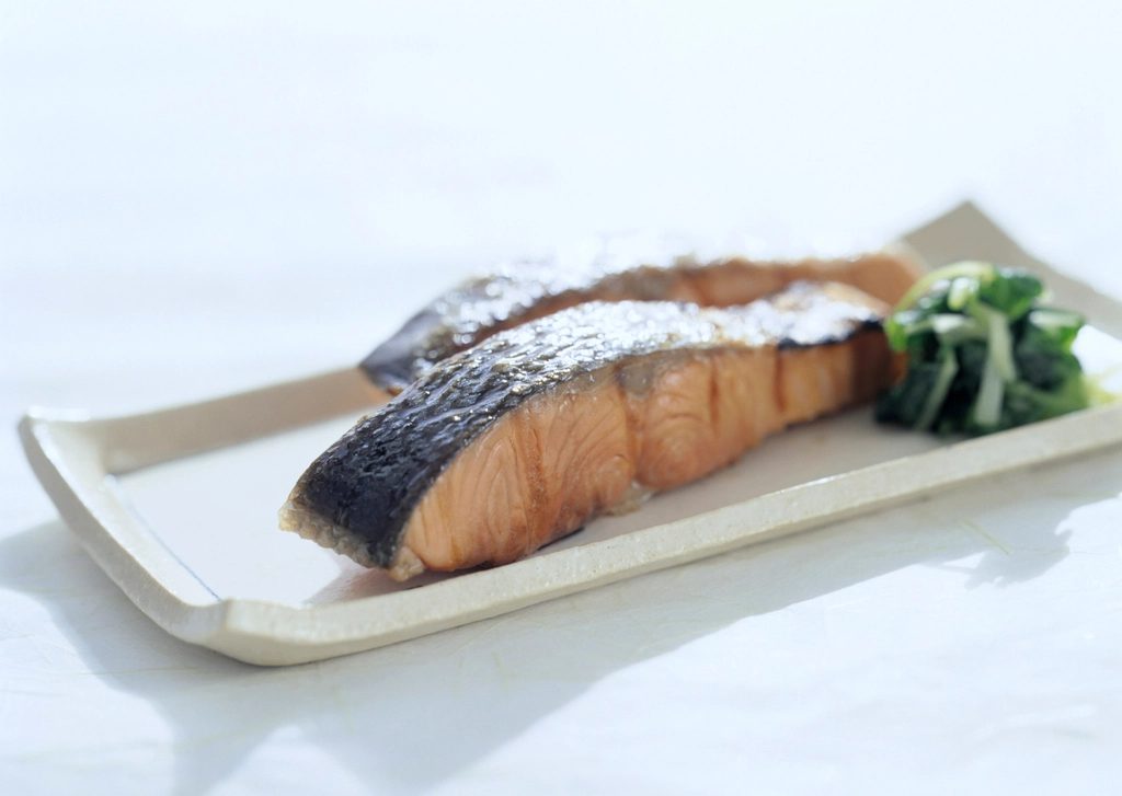 A grilled salmon fillet served with leafy greens and roasted vegetables, a blood-sugar-friendly high-protein dinner