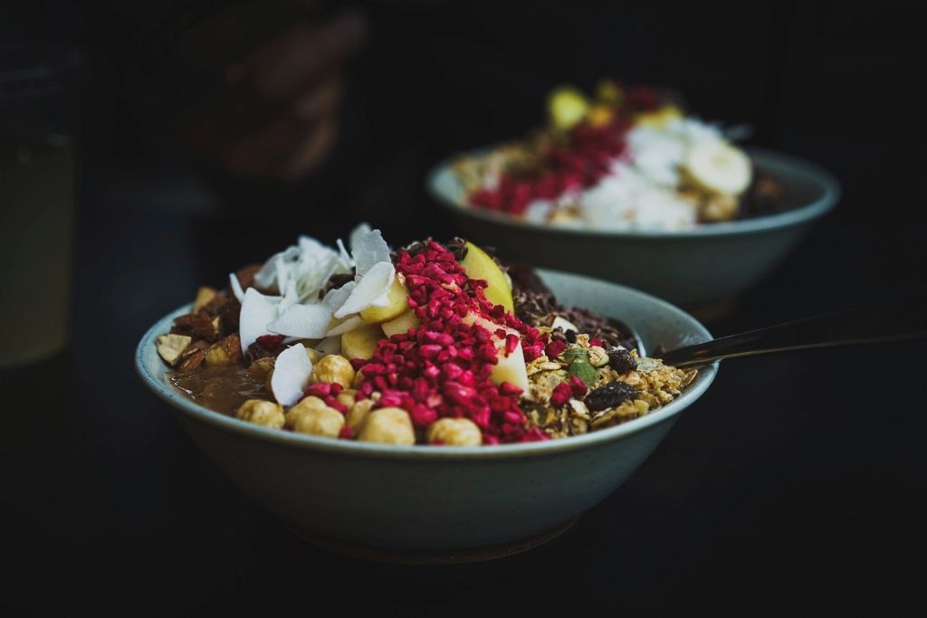 bowl of berries and a whole apple on a wooden table